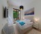 Bedroom 1 with a large double bed, wardrobe, and direct access to the terrace and garden