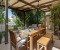 Terrace with a large dining table, a cozy lounge area, and a garden