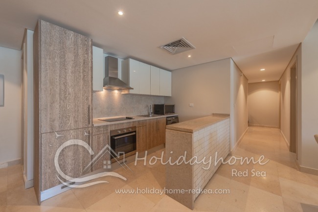 Full equipped kitchen with an adjoining living area , dining table, stove, oven, large fridge with freezer compartment, kettle, toaster, washing machine, microwave,