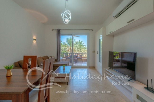 Living room with large Smart TV and access to the balcony