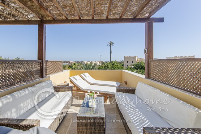 Private roof terrace with sun loungers and shaded seating area.