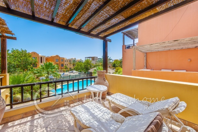 Spacious terrace with sunbdes and pool view.