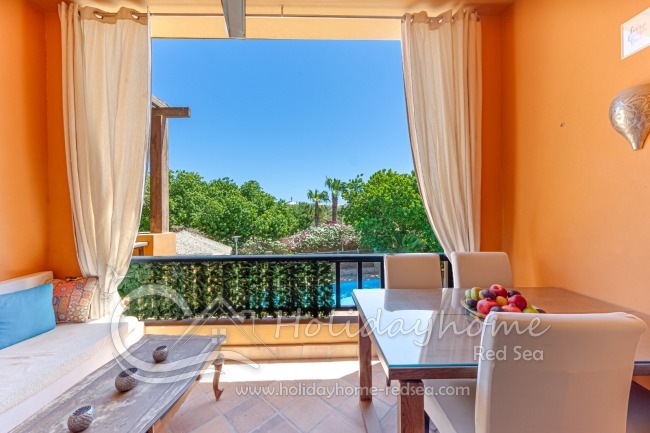 Balcony with seating area, dining table, and a view of the pool
