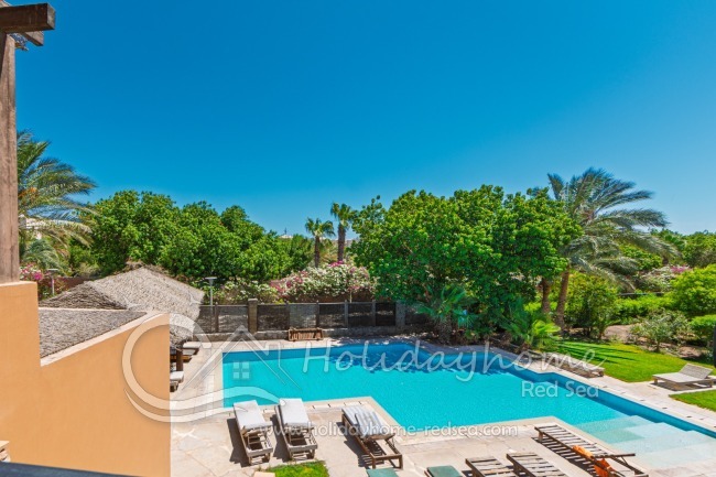 Shared pool with sun loungers and shaded seating areas