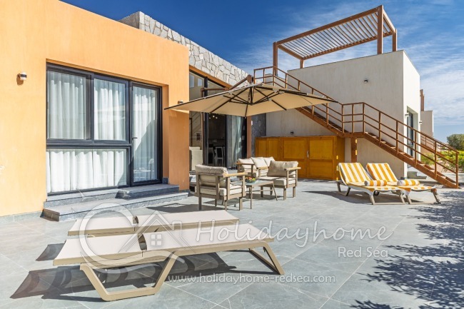 Large terrace with sunbeds, sitting area and umbrella