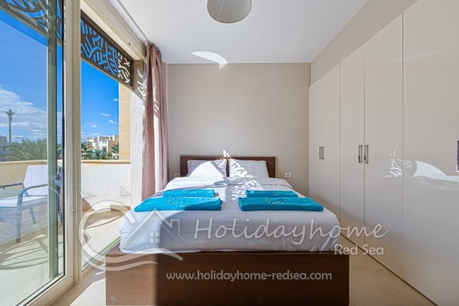 Bedroom with balcony and large wardrobe