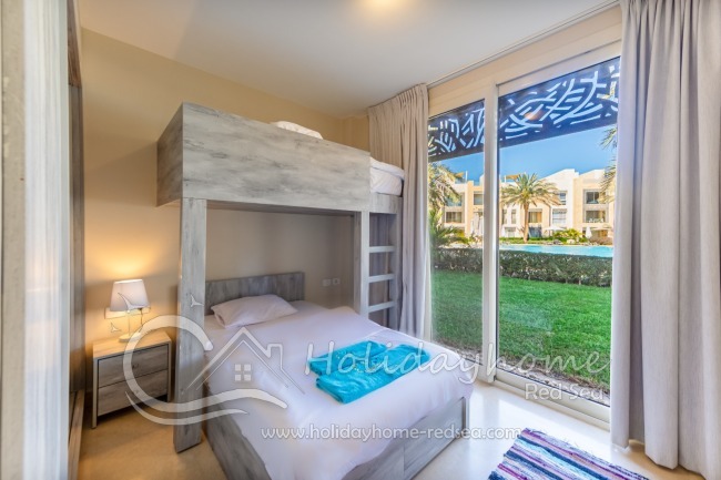 Bedroom 2 with bunkbed, garden and pool view