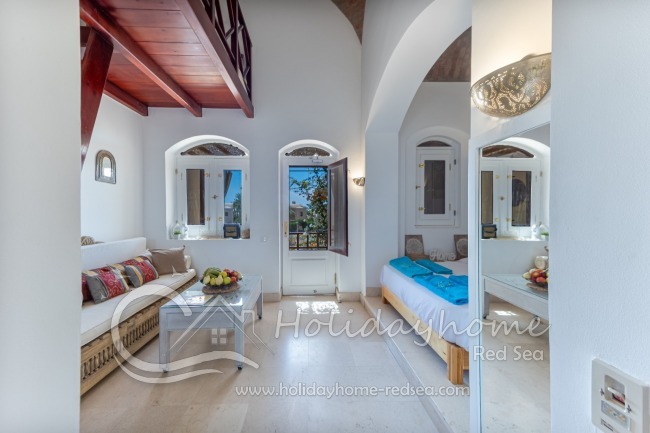 Oriental living area with additional sitting area on a platform and balcony