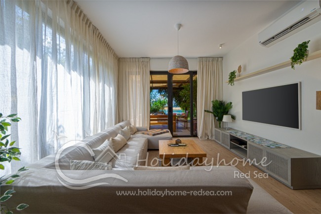 Living room with large smart TV and access to the terrrace and garden