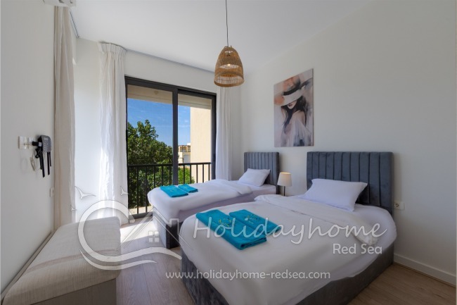 Bedroom 3 with two comfortable single beds, a wardrobe, and a bench